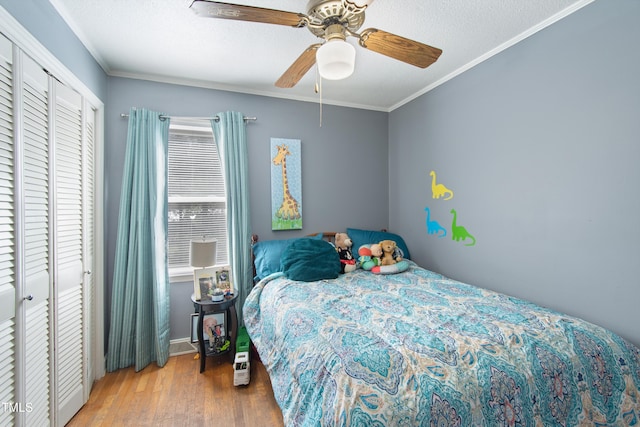 bedroom featuring a textured ceiling, hardwood / wood-style floors, a closet, ceiling fan, and ornamental molding