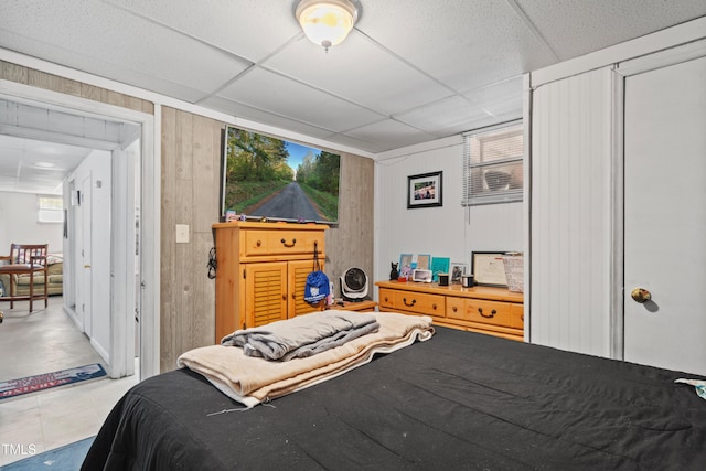 bedroom with wood walls and a drop ceiling