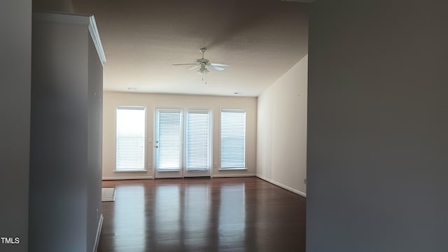 unfurnished room with ceiling fan and dark wood-type flooring