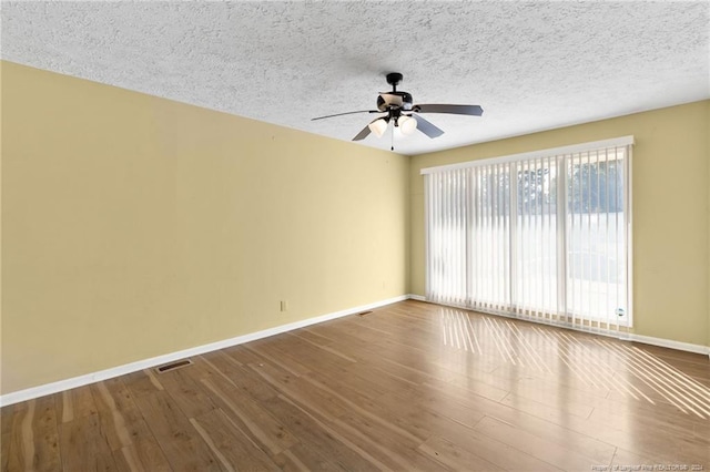 empty room with hardwood / wood-style floors, a textured ceiling, and ceiling fan