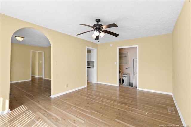 spare room featuring washer / dryer, hardwood / wood-style floors, a textured ceiling, and ceiling fan