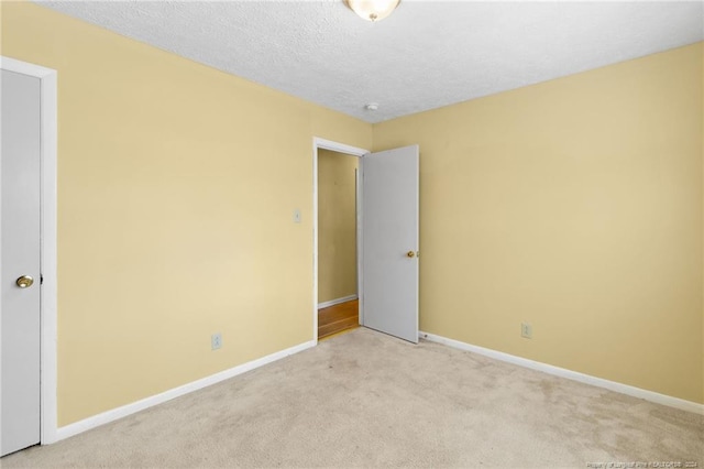 carpeted empty room featuring a textured ceiling