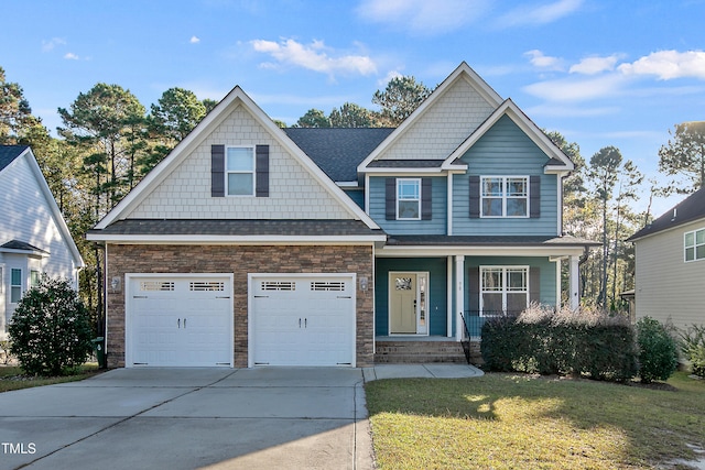 craftsman house featuring covered porch, a garage, and a front lawn