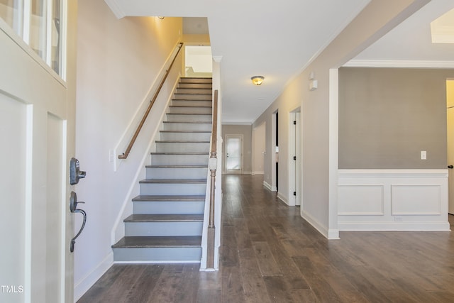 stairway with ornamental molding and hardwood / wood-style flooring