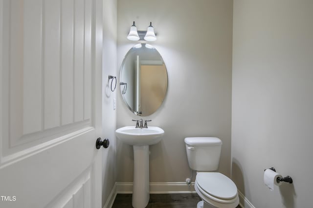 bathroom with toilet, hardwood / wood-style floors, and sink