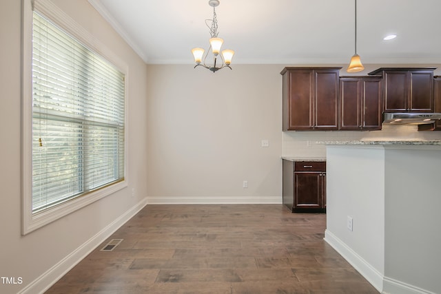 kitchen featuring crown molding, dark brown cabinetry, dark hardwood / wood-style floors, and hanging light fixtures