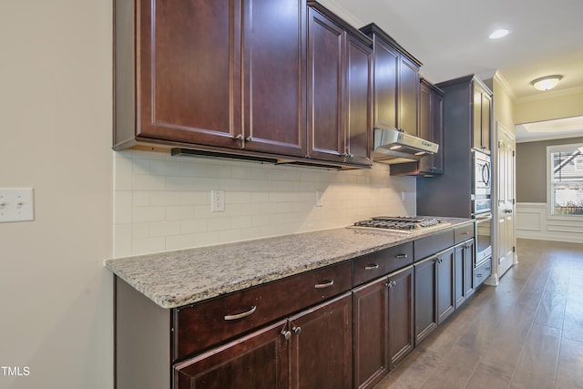 kitchen featuring light stone countertops, ornamental molding, appliances with stainless steel finishes, and hardwood / wood-style flooring