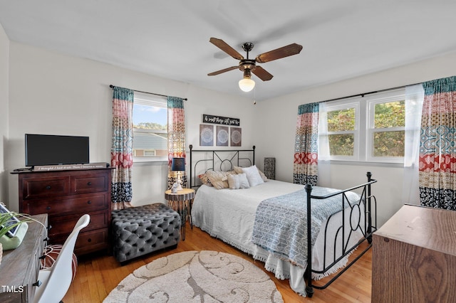 bedroom with multiple windows, light hardwood / wood-style floors, and ceiling fan