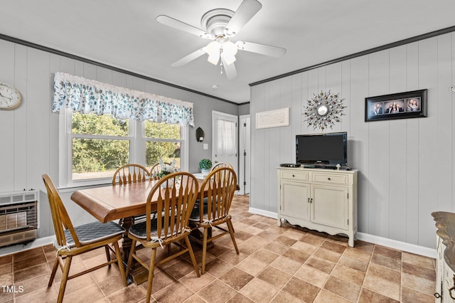 dining area with ornamental molding, wooden walls, heating unit, and ceiling fan