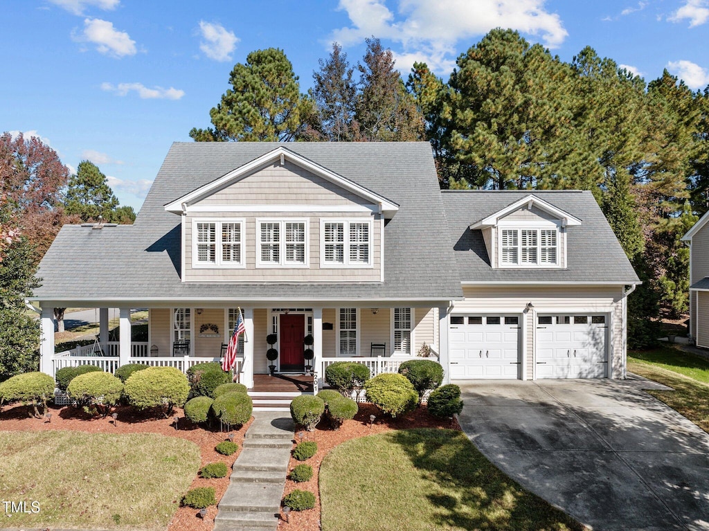 view of front of house featuring a front lawn, a garage, and a porch