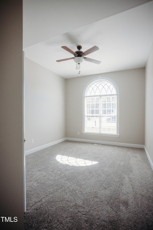 carpeted spare room featuring ceiling fan