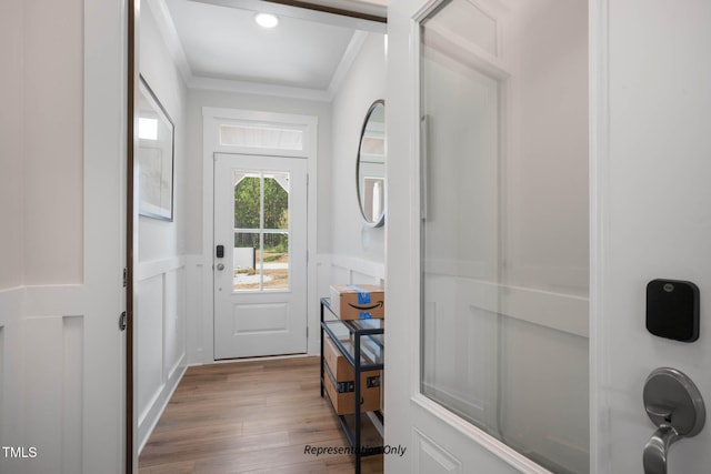 doorway to outside with light hardwood / wood-style floors and crown molding