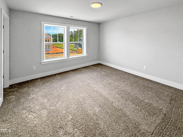 carpeted empty room featuring baseboards