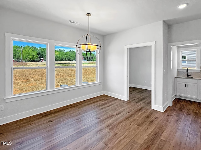 unfurnished dining area with a sink, plenty of natural light, and dark wood-type flooring