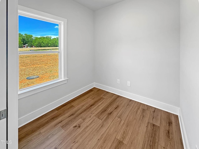 empty room with baseboards and wood finished floors