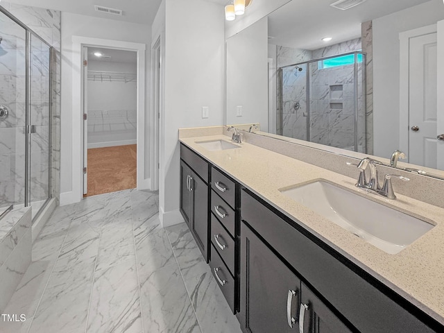full bathroom featuring marble finish flooring, a marble finish shower, and a spacious closet