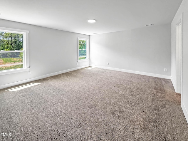 empty room featuring carpet and baseboards