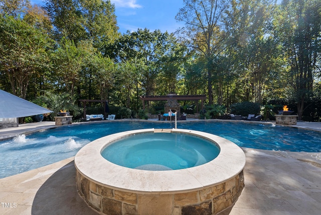 view of pool featuring pool water feature, a patio area, a pergola, and an in ground hot tub