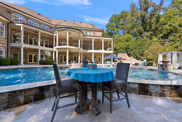 view of swimming pool with ceiling fan and a patio area