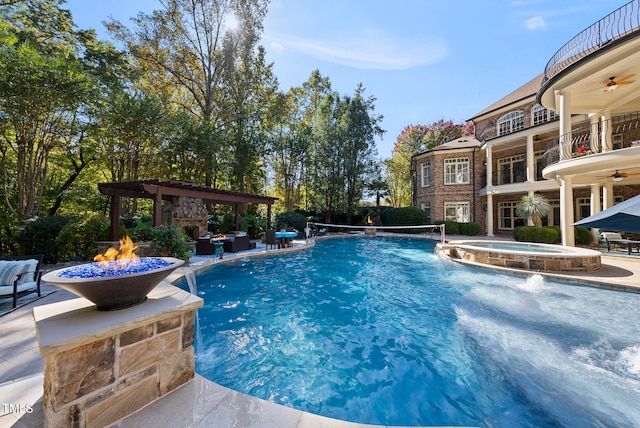 view of swimming pool with pool water feature, ceiling fan, an in ground hot tub, and a patio