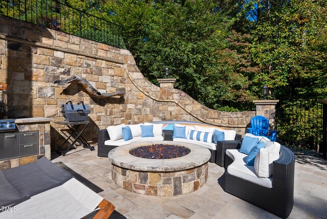 view of patio with grilling area and an outdoor living space with a fire pit