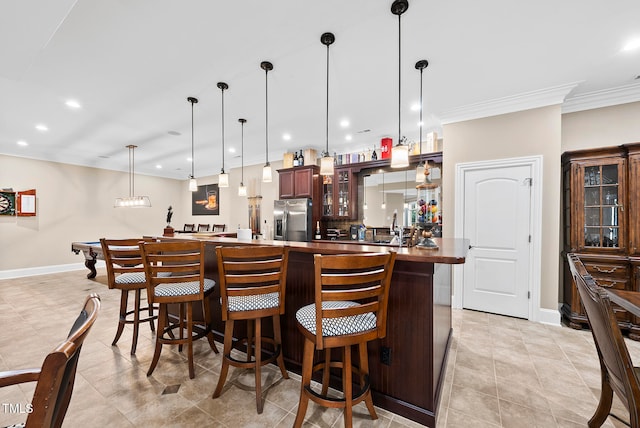 kitchen featuring kitchen peninsula, stainless steel fridge with ice dispenser, hanging light fixtures, and a breakfast bar