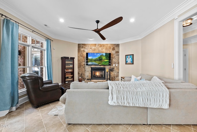 tiled living room with ceiling fan, ornamental molding, and a fireplace