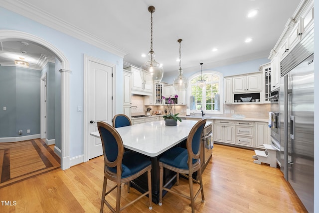 dining space with light wood-type flooring and ornamental molding