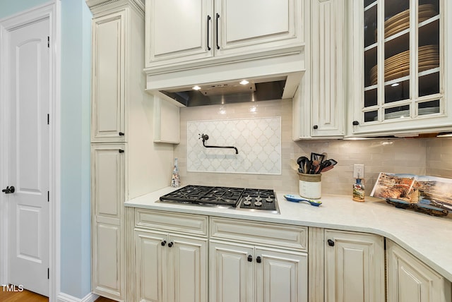 kitchen with decorative backsplash, light hardwood / wood-style floors, and stainless steel gas cooktop