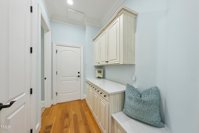 mudroom featuring light wood-type flooring and crown molding