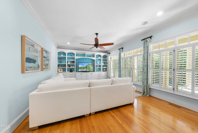 living room with crown molding, light hardwood / wood-style flooring, and ceiling fan