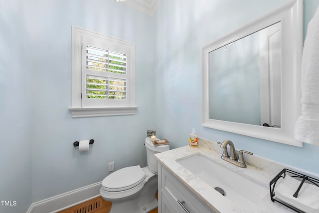 bathroom with wood-type flooring, vanity, ornamental molding, and toilet