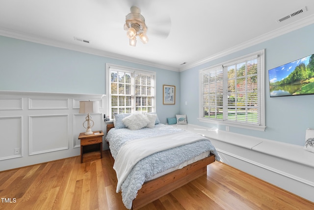 bedroom featuring light hardwood / wood-style flooring, ceiling fan, and crown molding