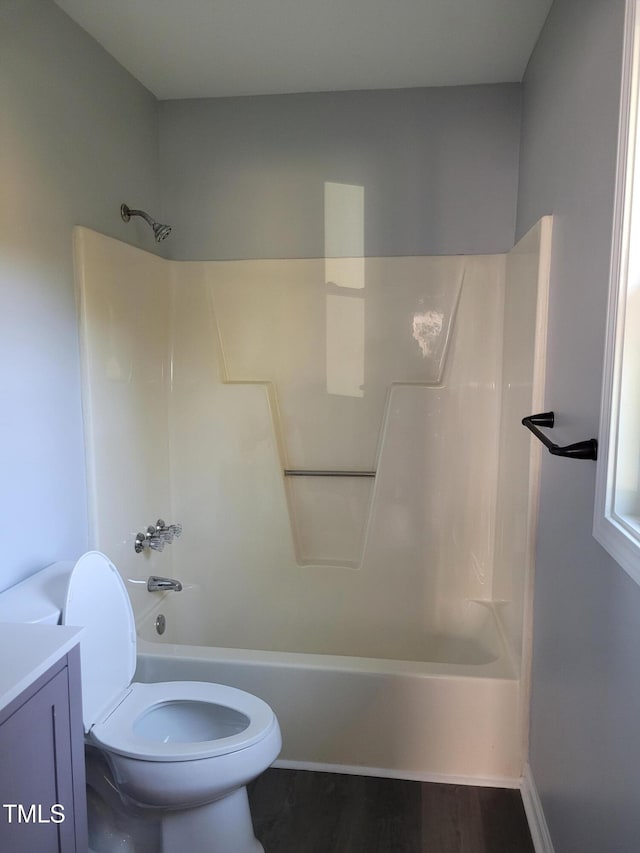 full bathroom with toilet, hardwood / wood-style floors, vanity, and  shower combination