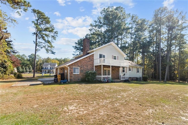 view of front facade with a balcony, a porch, and a front yard