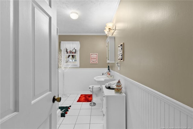 bathroom with tile patterned floors, ornamental molding, and sink