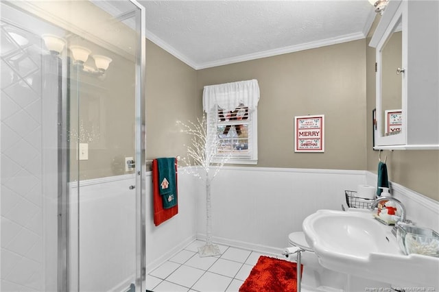 bathroom with tile patterned floors, walk in shower, ornamental molding, a textured ceiling, and sink