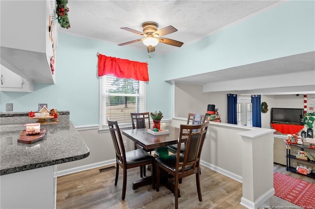 dining area featuring ceiling fan, crown molding, a textured ceiling, and hardwood / wood-style flooring