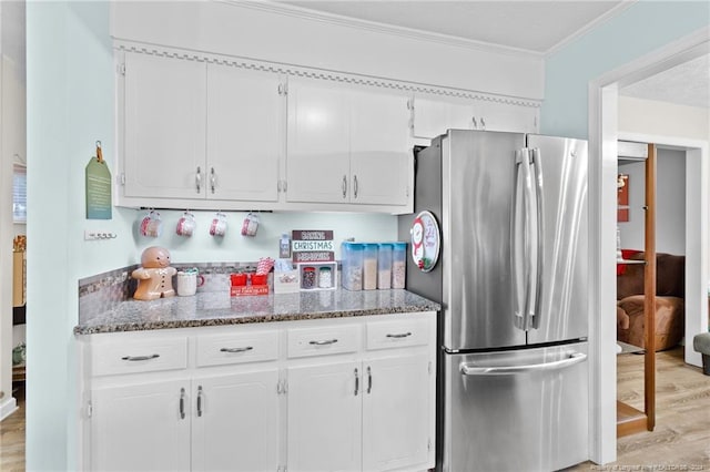 kitchen with stainless steel refrigerator, white cabinetry, crown molding, and light hardwood / wood-style floors