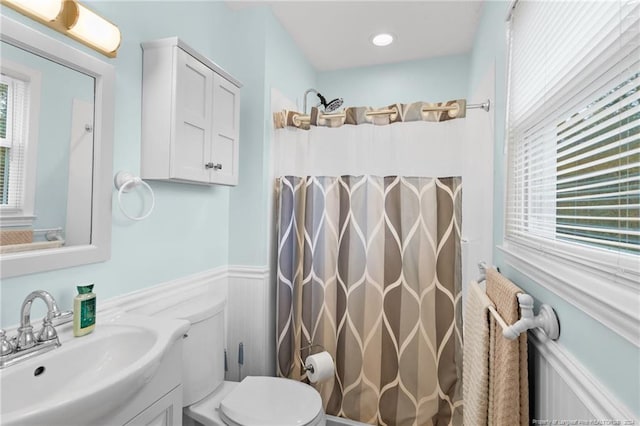 bathroom with walk in shower, vanity, a healthy amount of sunlight, and toilet