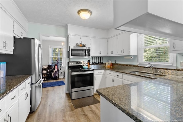 kitchen with sink, stainless steel appliances, light hardwood / wood-style floors, a textured ceiling, and white cabinets