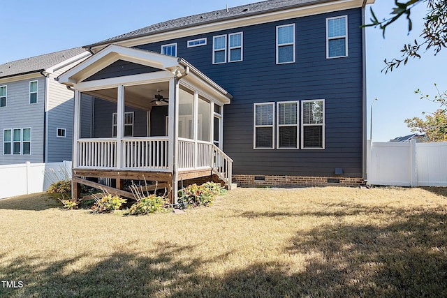 rear view of house featuring a sunroom, a yard, and ceiling fan