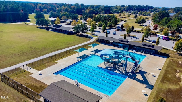 view of pool with a patio and a lawn