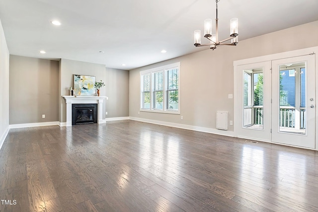 unfurnished living room with dark hardwood / wood-style flooring and an inviting chandelier