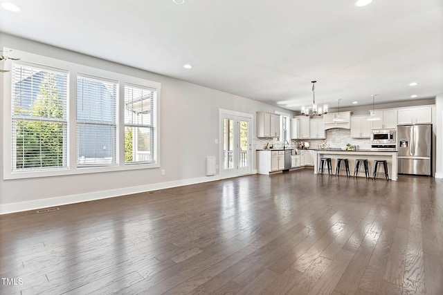 living room featuring a chandelier, dark wood-type flooring, and sink