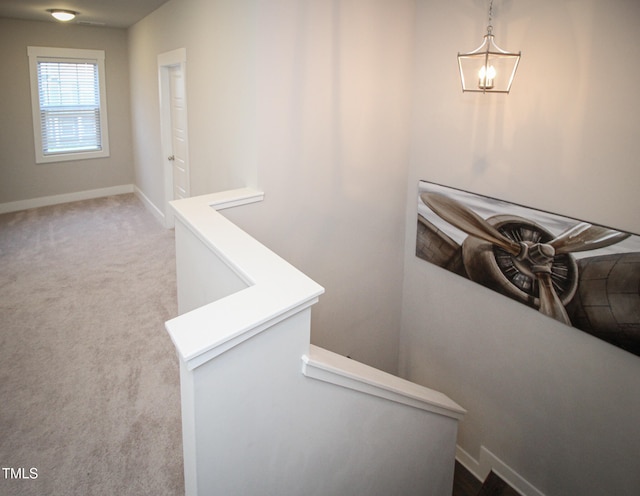 stairs featuring a notable chandelier and carpet flooring