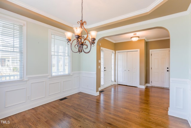 entryway with crown molding, dark wood-type flooring, and a notable chandelier