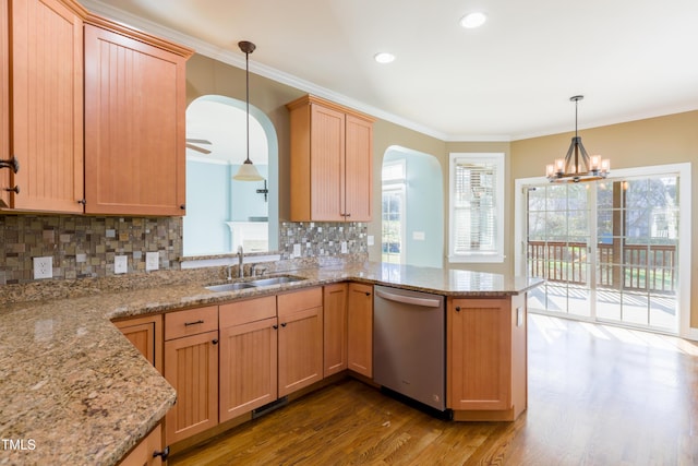 kitchen featuring dishwasher, pendant lighting, ornamental molding, sink, and kitchen peninsula