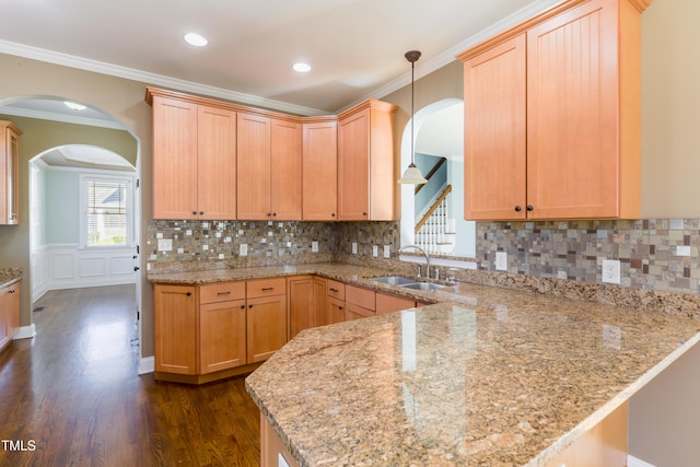 kitchen featuring sink, kitchen peninsula, light stone countertops, and light brown cabinetry