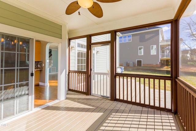 unfurnished sunroom with ceiling fan